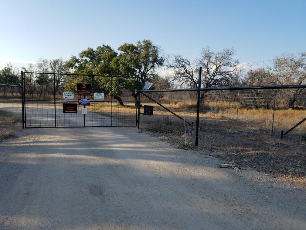 Black welded wire double drive metal gate at game ranch entrance — Brownwood TX